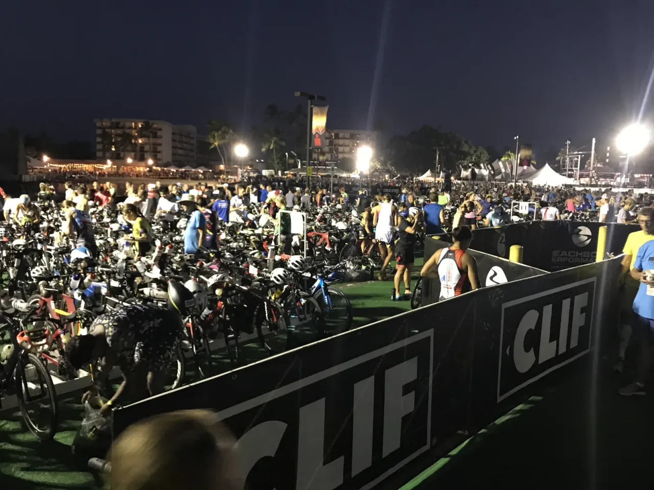 夜明け前のトランジションエリア。ライトに照らされて選手と機材が動き出すIRONMANの朝の景色
