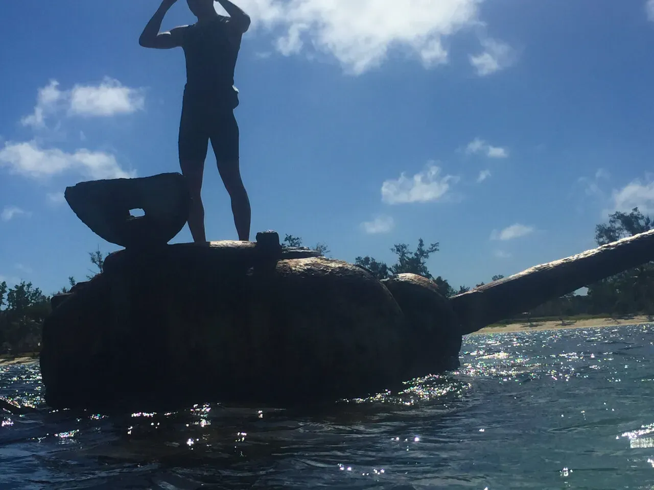 海に沈む戦車の上に立つシルエット